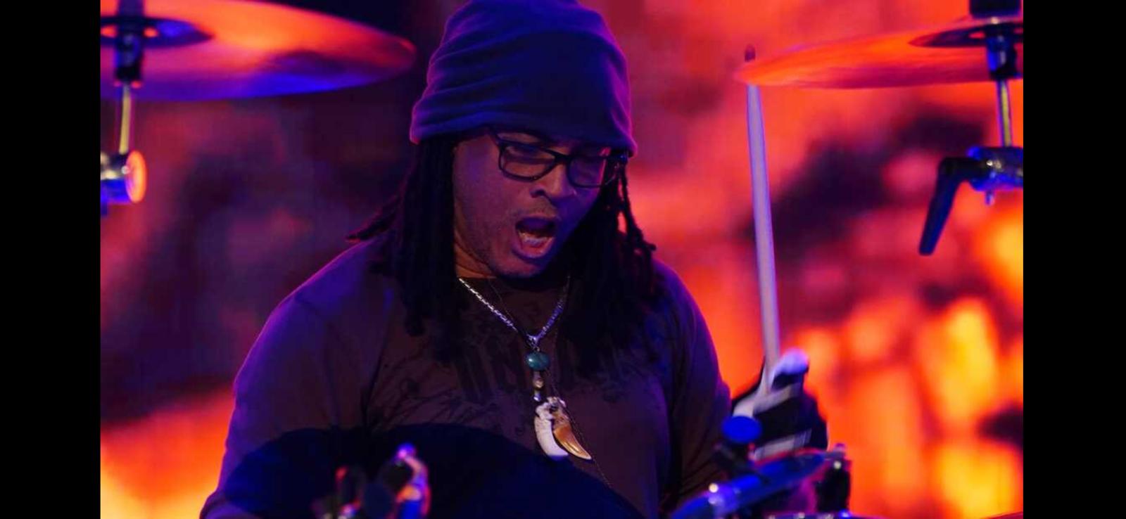 Paul KasticK performing under purple stage lights